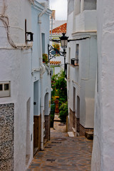 Fototapeta na wymiar Tiled narrow streets in the Spanish white village of Competa on the Costa Del Sol, Andalusia, Spain