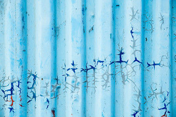 Metal curly sheets are painted in sky-blue color, old cracked paint. Abstract grunge texture.