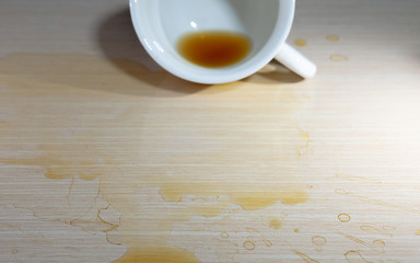 Coffee drink spilled onto a wooden floor.