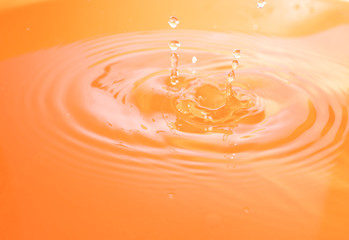 Water drop falling and drips in colored glass. Water drop splash and make perfect circles and...
