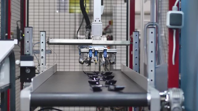 Automatic Plastic Injection Molding Machine, Robotics Arm Inserts Plastic Component for the Automotive Industry on the Conveyor Belt from the Injection Mold in Automotive Factory
