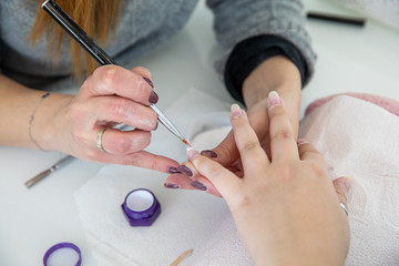 Manicure process in beauty salon - woman hand nails care.