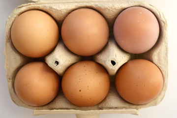 Pack of six free range eggs on white background. Top view.