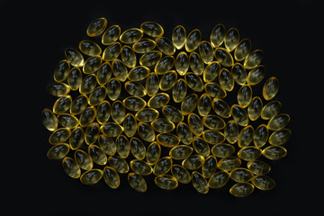 Vitamin d or omega 3 gel capsules on black
