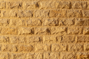 Wall with rough brickwork. Masonry of yellow sand brick blocks. Natural background for decorating modern buildings in the antique style.