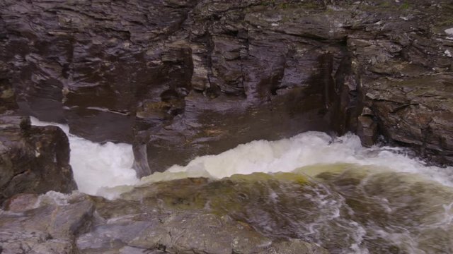 Medium high angle still shot of River Dee's churning waterfall at Linn of Dee, Aberdeenshire, Scotland