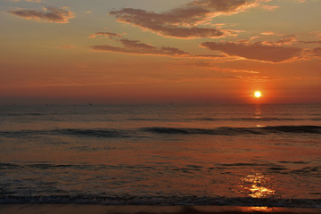 Fototapeta na wymiar sunset in a ocean with a waves and a beautiful sky in goa beach