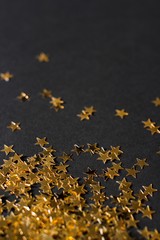 gold sparkly glitter stars on black background