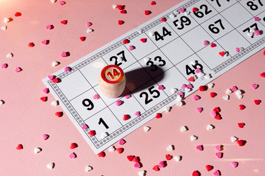 Lotto ticket with wood barrel 14 number on pink hearts background. Valentines day 14 february minimal concept.