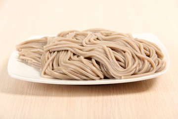 Boiled gray flour pasta on a porcelain plate