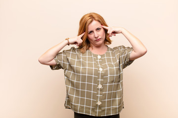middle age woman looking concentrated and thinking hard on an idea, imagining a solution to a...