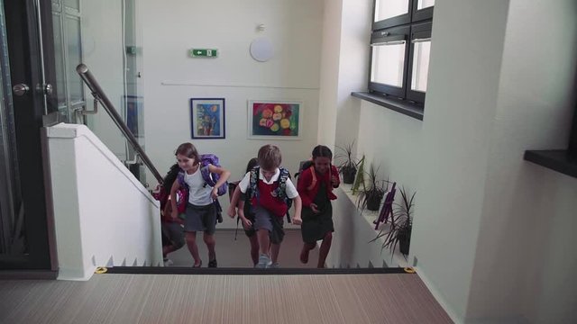 Group Of Cheerful Small School Kids Running Up The Stairs.