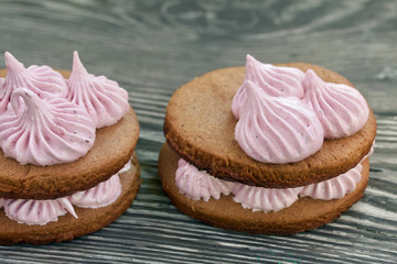 Marshmallows sandwiches made from chocolate dough and blueberry marshmallows. On brushed pine boards. Close-up shot.