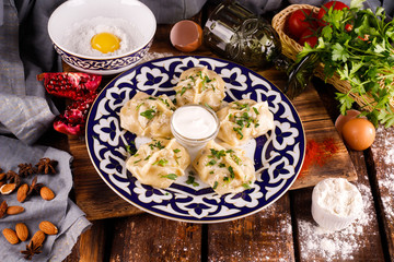 Georgian khinkali dumplings with meat, herbs and tomato hot sauce Satsebeli on a plate