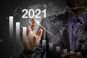 Man's hand pointing graph of success in 2021 year. Growing business concept