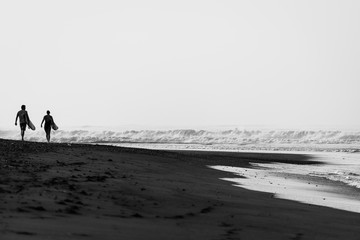 Fototapeta na wymiar silhouette of surfers on the beach