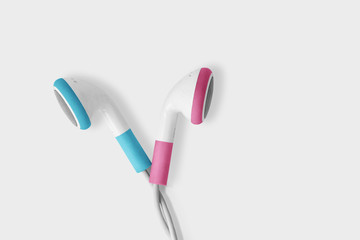 Blue and pink earphones opposite each other on white background - Concept of communication problems between men and women (gender communication)