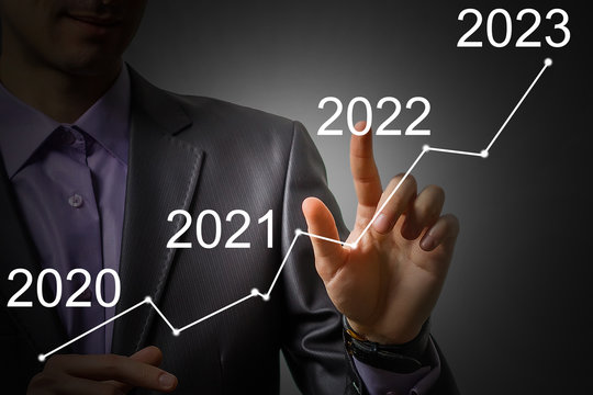 Man's hand pointing graph of success in 2022 year. Growing business concept