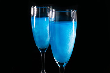 two glasses with blue sparkling champagne