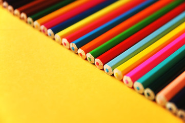 Set of colored pencils on a yellow background     