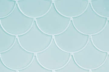 Light blue ceramic tiles in the form of scales. Mosaic Tiles on the wall