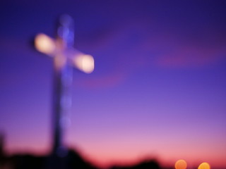 Abstract religious cross, with sunset in the background 