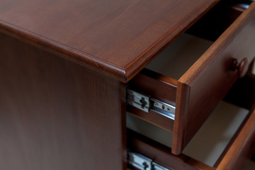 Classic brown desk with an open drawers.