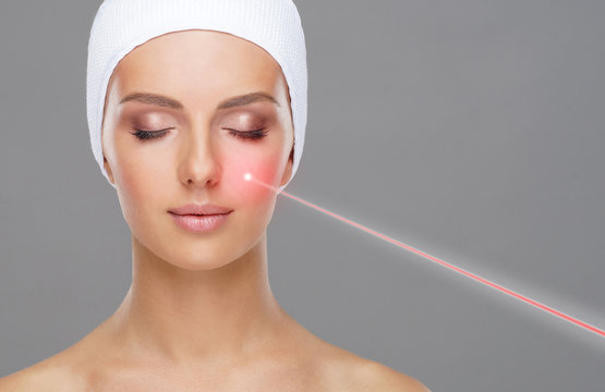 Doctor removing moles using laser ray. Beauty portrait of a young woman. Birthmark removal, plastic surgery, skin lifting and aesthetic medicine.