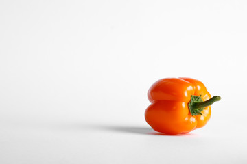 A single orange color bell pepper. Backside view