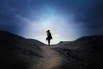 Silhouette of a person walking in a mountain path. 16:9 panorama