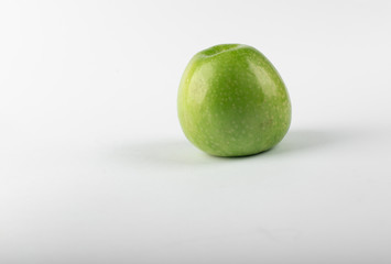 A single green fresh apple isolated on white background. side view