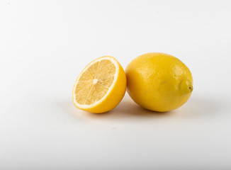 Whole and half lemon isolated on white.