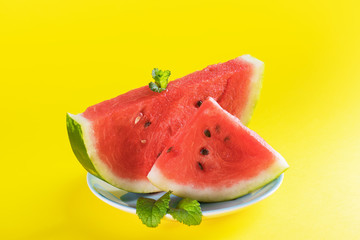Fresh watermelon on light yellow background. Watermelon slices on a plate. Healthy Summer Snack Concept, copy space