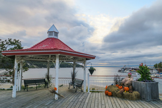 Haloween decorations in a red and white kiosk in front of Tadoussac old port on a cloudy day