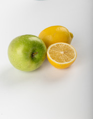 Naklejka na ściany i meble Whole and half lemon isolated on white with a green apple