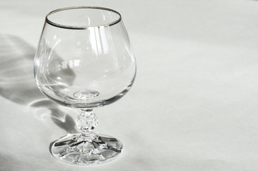 glass for alcohol, cognac on a light background. Dishes made of crystal.