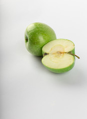 Whole and half green apple isolated on white