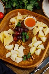 wooden plate with fried cheese, grape and sauce