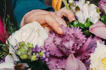 Florist at work makes a fashionable modern bouquet of different flowers.