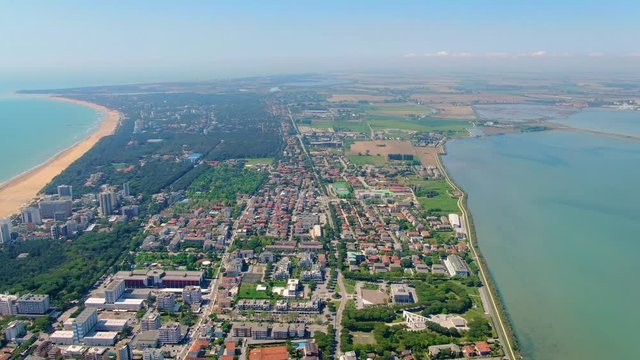 Aerial shot of Lignano Sabbiadoro town surrounded by Adriatic sea and Marano Lagoon, Italy