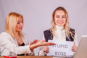 Funny picture: worker laughs at her boss with sign: Stupid boss.