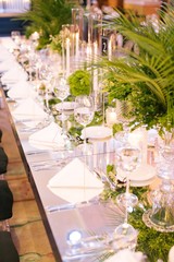 Palm tree leaf wedding table. Candles, napkins and mirrored tables.