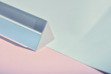 prism lying on soft pastel blue and pink paper as fashion background with copy space