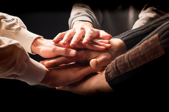 Friends with stack of hands showing unity and teamwork