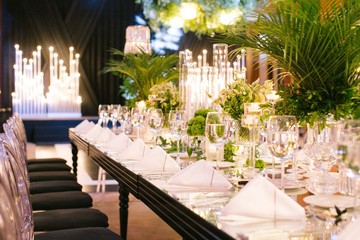 Palm tree leaf wedding table. Candles, napkins and mirrored tables.
