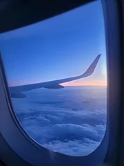 Papier Peint photo Avion Beautiful view through the open window in airplane on the wing and clouds at sunrise litght