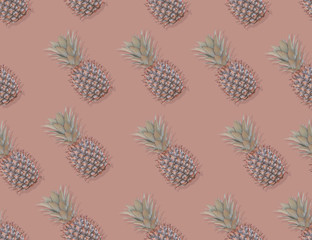 Pattern with pineapples on pastel background. Colorful fruit pattern of fresh pineapples on pink pastel background. Top view on pineapples.