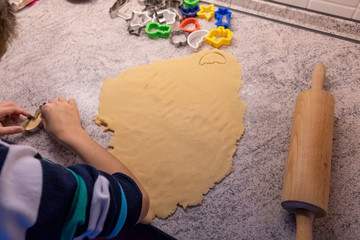 A child bakes cookies with mum or grandma, rolls out the dough and uses moulds to make the cookie cuttings.