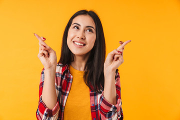 Photo of dreaming young woman smiling with fingers crossed