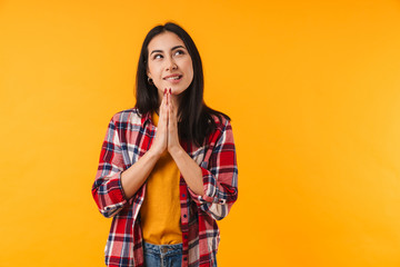 Photo of dreaming young woman smiling and holding palms together